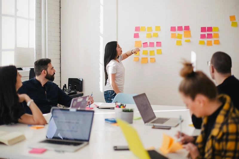 Confident business leader giving a presentation to a team, illustrating effective leadership and communication strategies in a modern office setting