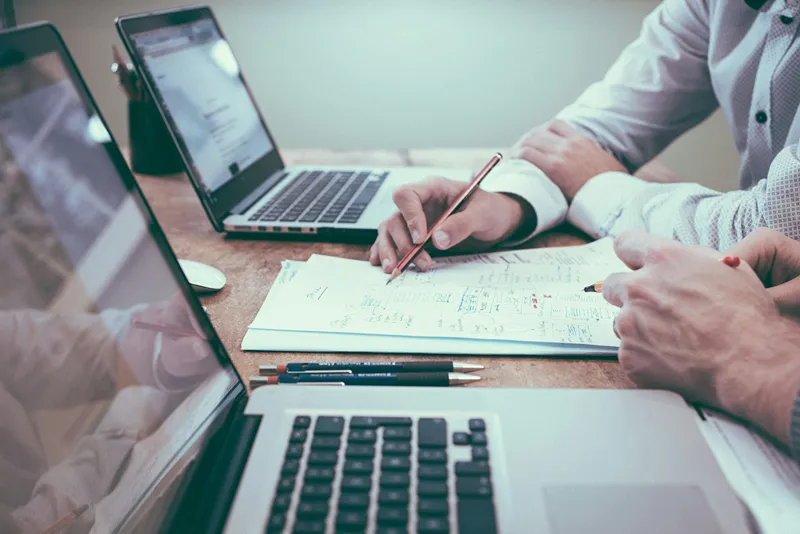 Professional analyzing financial data and charts on a laptop, representing the use of browser extensions for complex calculations across industries.